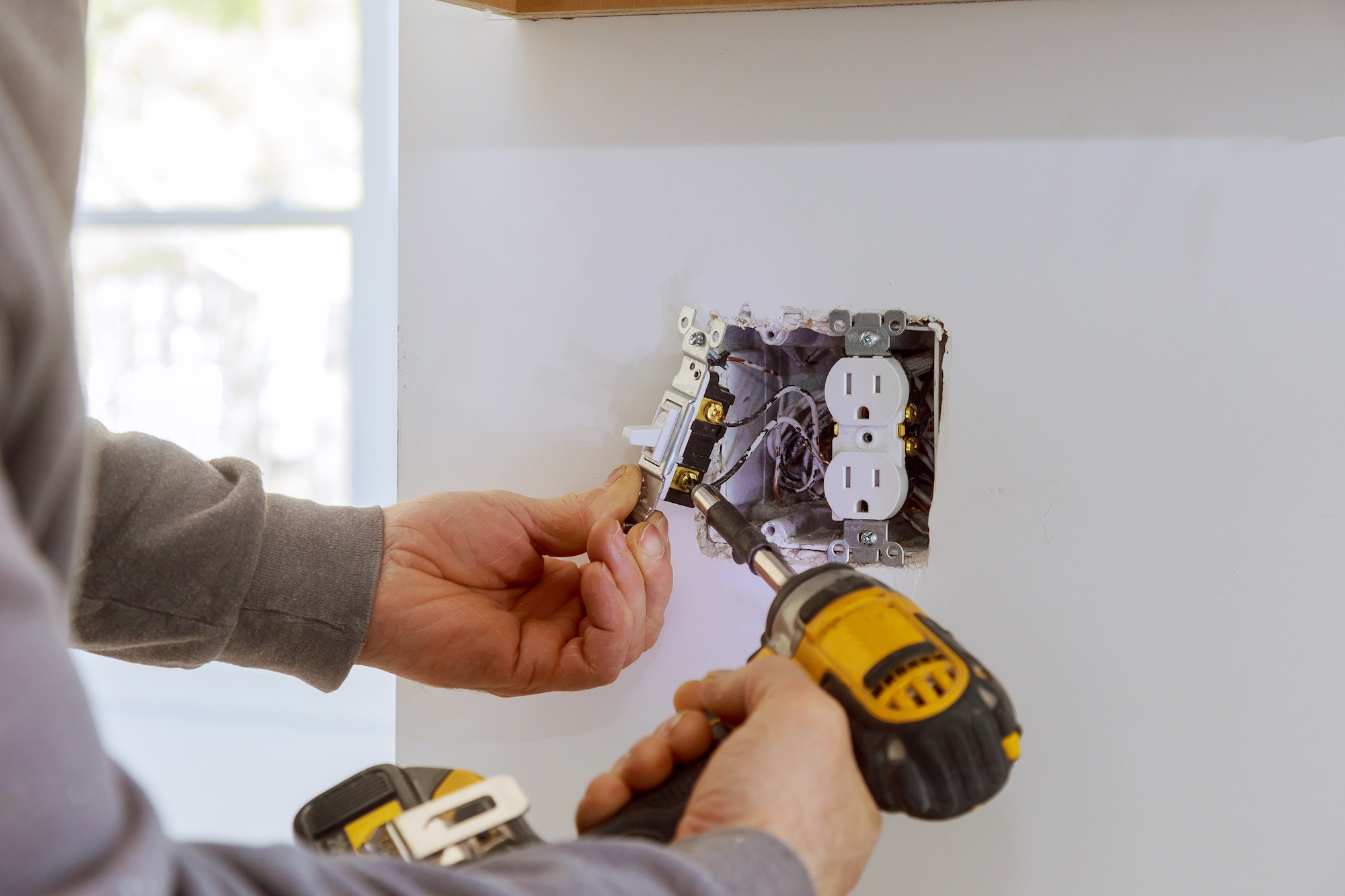 Work on installing electrical outlets with electrical wires and connector installed in plasterboard